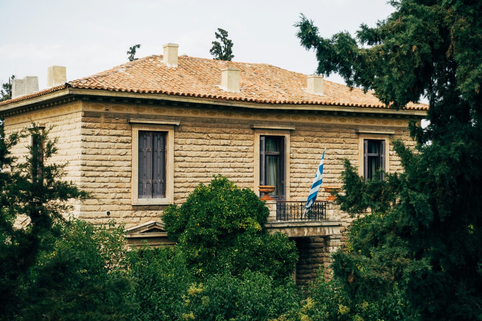 brown concrete house near green trees during daytime